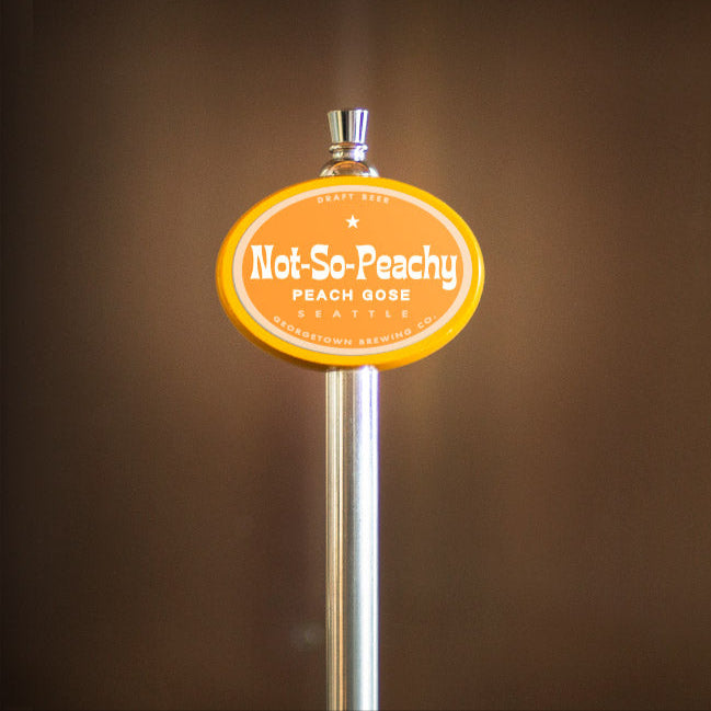 Beer tap handle with 'Not So Peachy' label against a brown background