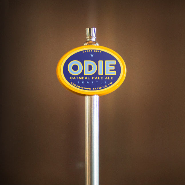 ODIE beer tap handle against a brown background