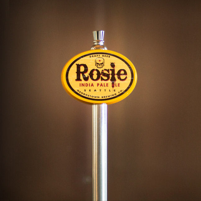 Rosie India Pale Ale tap handle against a brown background