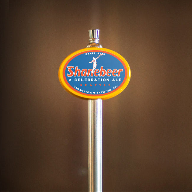 Shanebeer beer tap handle with logo on a brown background