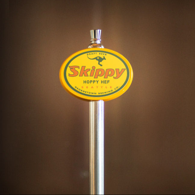 Skippy beer tap handle against a brown background
