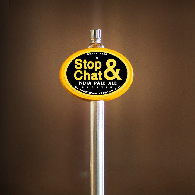 Beer tap handle with 'Stop & Chat' label against a brown background
