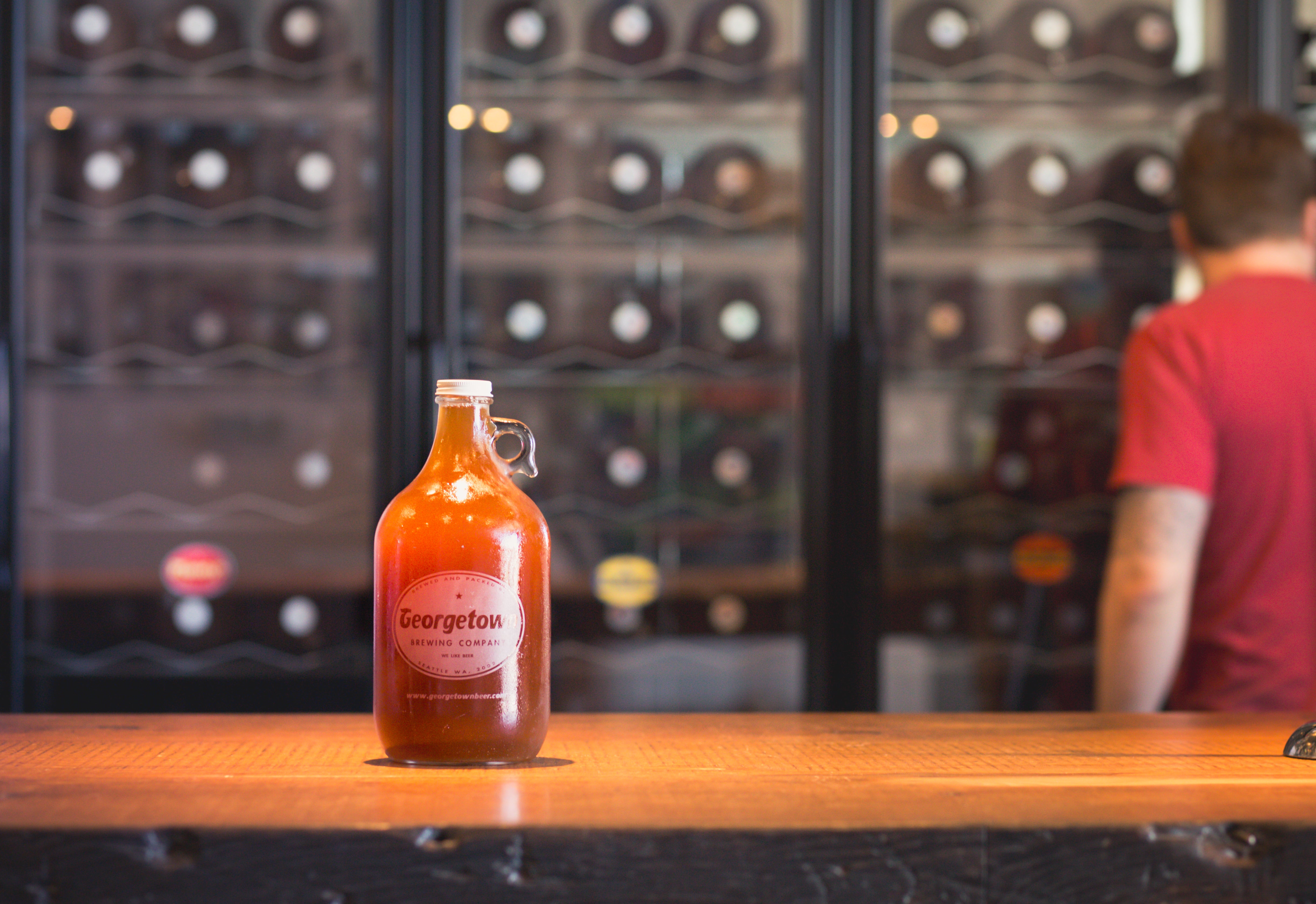 a delicious full growler on the counter of manny's pale ale at georgetown brewery's taproom