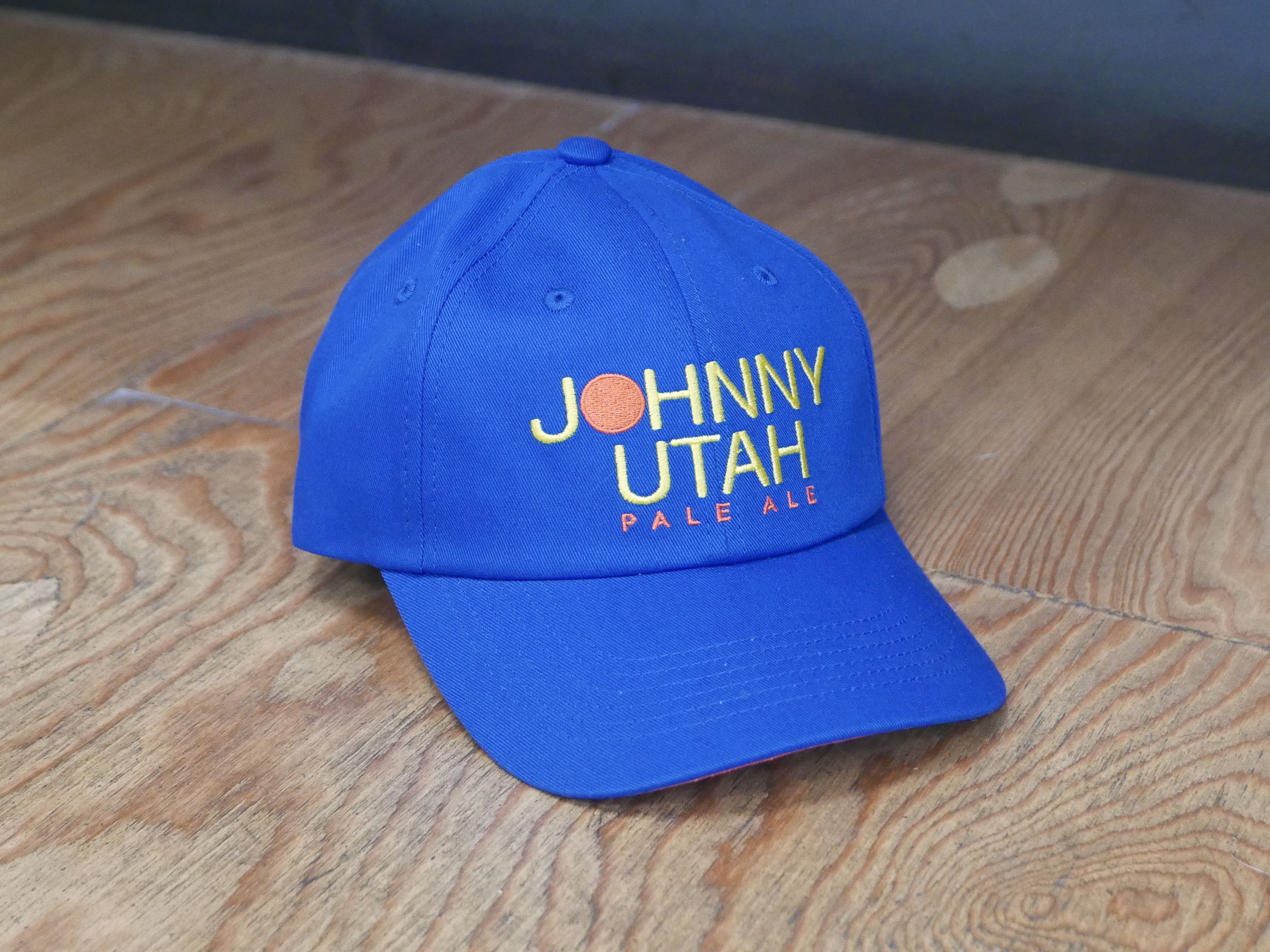 royal blue hat with Johnny Utah Pale Ale embroidered in Yellow and orange